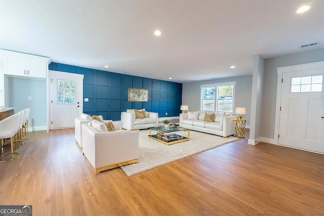 living room featuring a wealth of natural light, visible vents, light wood finished floors, and recessed lighting