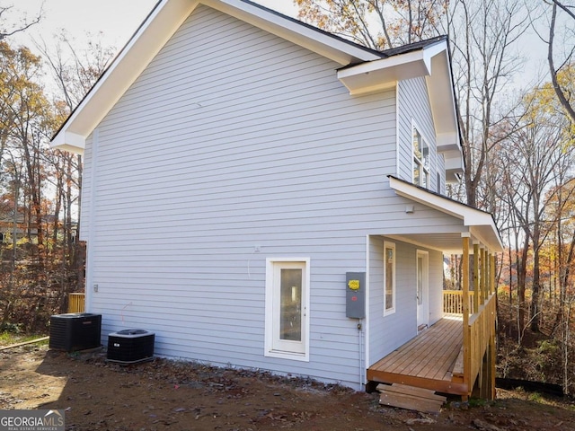 view of side of home with a deck and central air condition unit