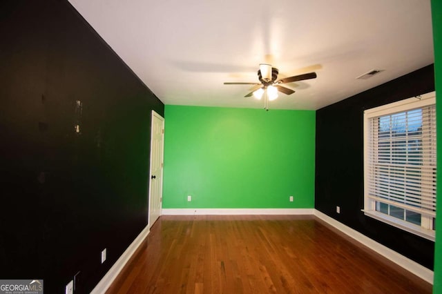 unfurnished room featuring ceiling fan and dark wood-type flooring