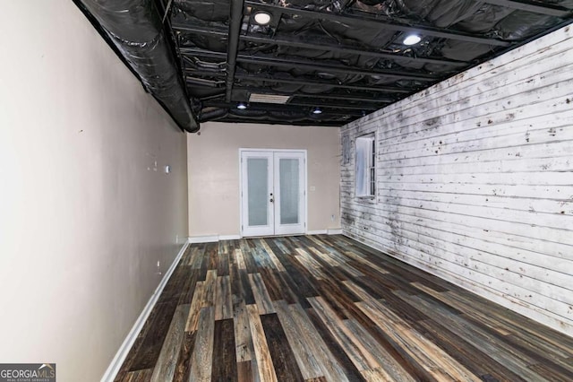 hallway with wood walls, french doors, and hardwood / wood-style floors