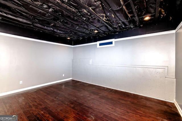 basement featuring hardwood / wood-style floors and crown molding