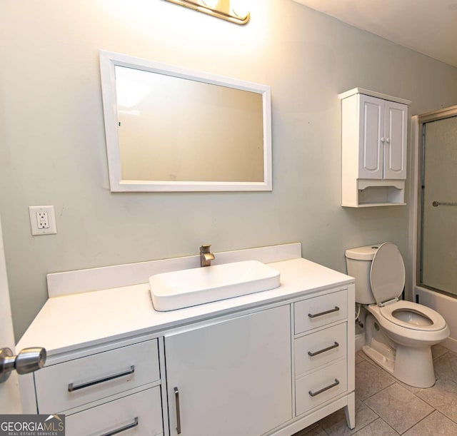 full bathroom featuring shower / bath combination with glass door, tile patterned flooring, vanity, and toilet