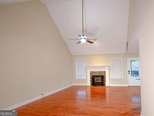 unfurnished living room with a fireplace, wood-type flooring, high vaulted ceiling, and ceiling fan