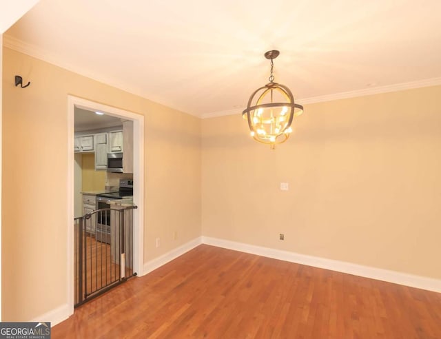 unfurnished dining area featuring ornamental molding, wood-type flooring, and a notable chandelier