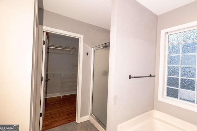 bathroom with wood-type flooring and plus walk in shower