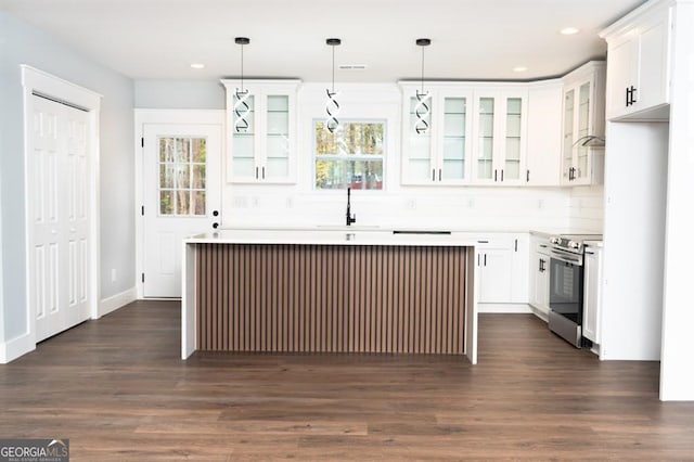 kitchen featuring sink, decorative light fixtures, white cabinets, a kitchen island, and stainless steel electric range