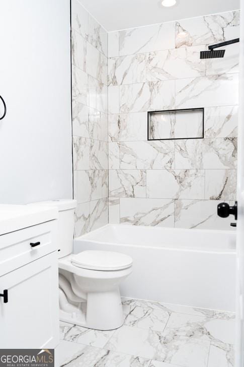 bathroom with tiled shower / bath combo and toilet