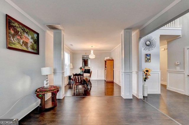 hallway with ornamental molding, dark wood-type flooring, and ornate columns