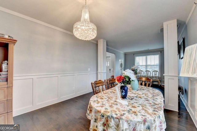 dining area with dark hardwood / wood-style flooring, an inviting chandelier, and ornamental molding