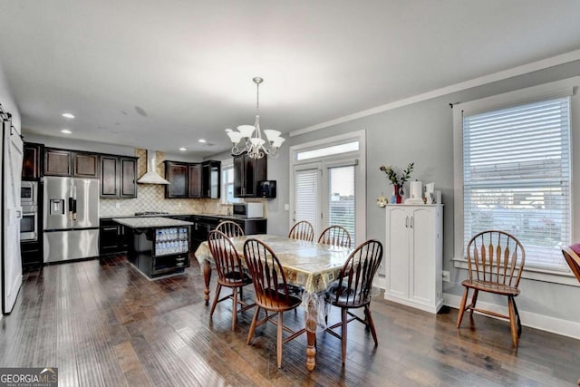 dining area with a barn door, a wealth of natural light, dark hardwood / wood-style flooring, and crown molding