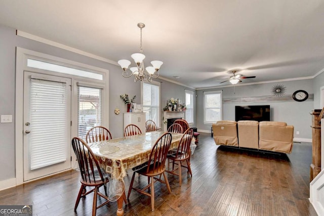 dining room featuring plenty of natural light, dark hardwood / wood-style flooring, ornamental molding, and ceiling fan with notable chandelier