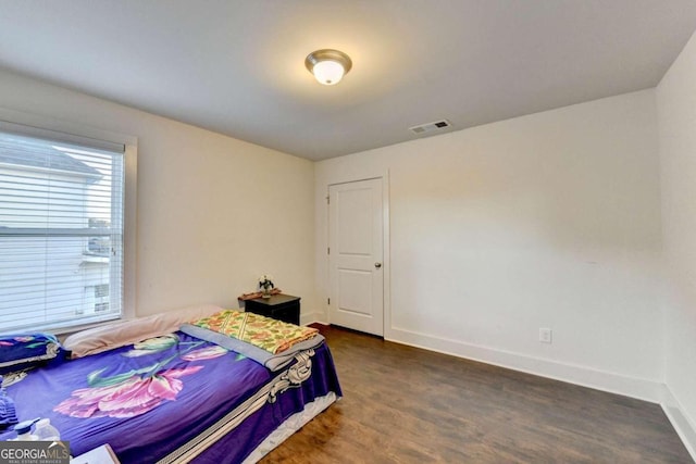 bedroom with dark wood-type flooring