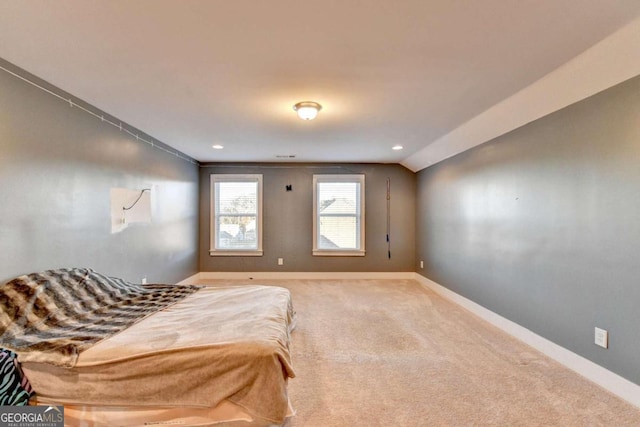 carpeted bedroom with lofted ceiling