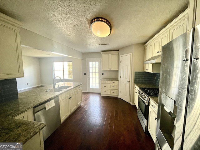 1529 Evergreen Hollow Ln, Conyers, GA 30012 - kitchen with stainless steel appliances, a sink, backsplash, dark wood-style flooring, and dark stone counters