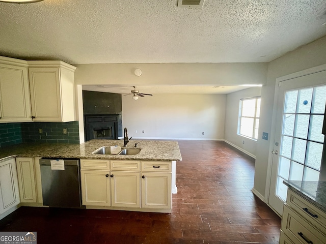 kitchen with dark wood-type flooring, sink, stainless steel dishwasher, ceiling fan, and light stone counters