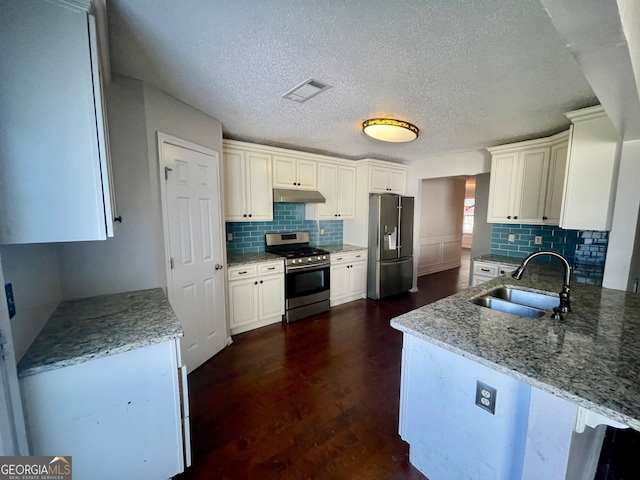 kitchen featuring light stone countertops, appliances with stainless steel finishes, dark wood-type flooring, sink, and white cabinets