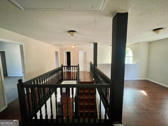 hallway featuring a textured ceiling and dark wood-type flooring