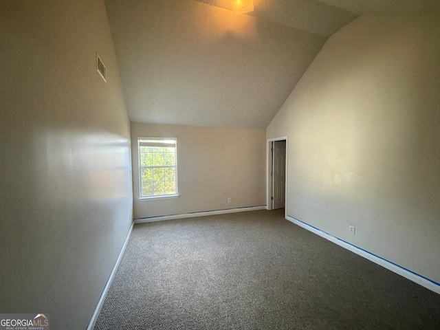 empty room featuring carpet flooring and lofted ceiling