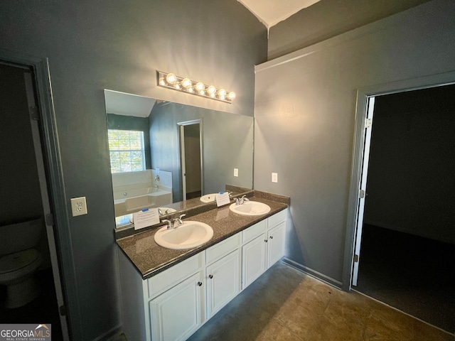 bathroom featuring a bath, vanity, and toilet