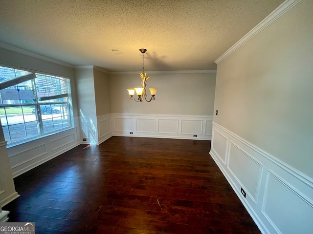 unfurnished dining area featuring a textured ceiling, crown molding, dark wood-type flooring, and an inviting chandelier