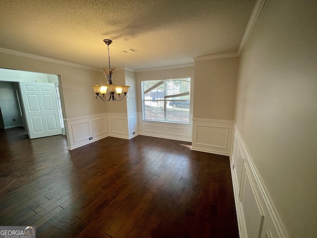 1529 Evergreen Hollow Ln, Conyers, GA 30012 - unfurnished dining area with a chandelier, dark wood finished floors, a textured ceiling, crown molding, and a wainscoted wall