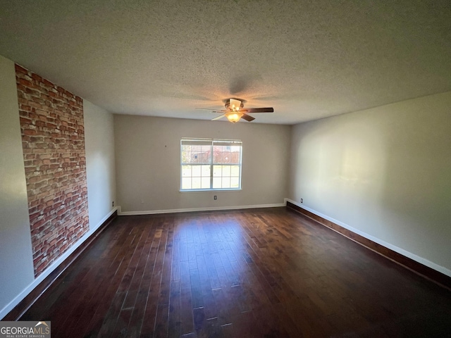1529 Evergreen Hollow Ln, Conyers, GA 30012 - empty room featuring a ceiling fan, dark wood-style flooring, baseboards, a textured ceiling, and brick wall