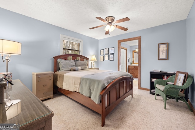 carpeted bedroom featuring ceiling fan, ensuite bathroom, and a textured ceiling