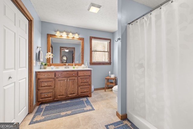 bathroom featuring vanity, a textured ceiling, toilet, and ceiling fan