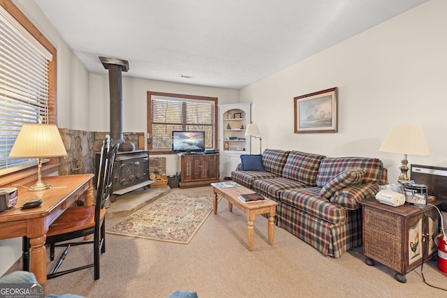 carpeted living room featuring a textured ceiling and a wood stove