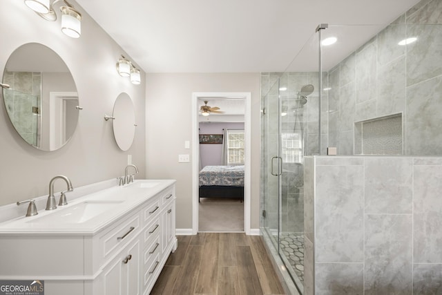 bathroom featuring wood-type flooring, vanity, an enclosed shower, and ceiling fan