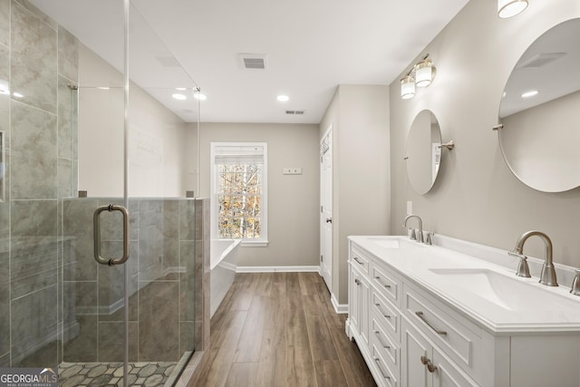 bathroom with hardwood / wood-style floors, vanity, and a shower with door