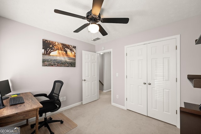 office featuring light carpet, ceiling fan, and a textured ceiling