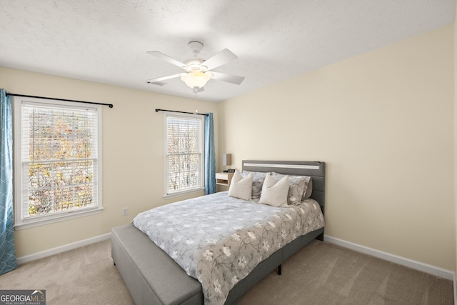 carpeted bedroom featuring a textured ceiling and ceiling fan