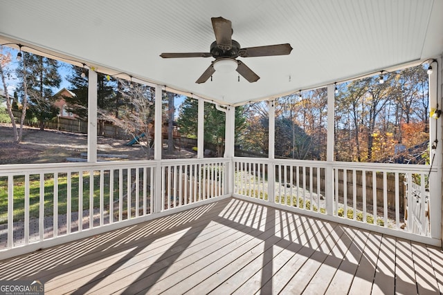 unfurnished sunroom featuring ceiling fan and a healthy amount of sunlight