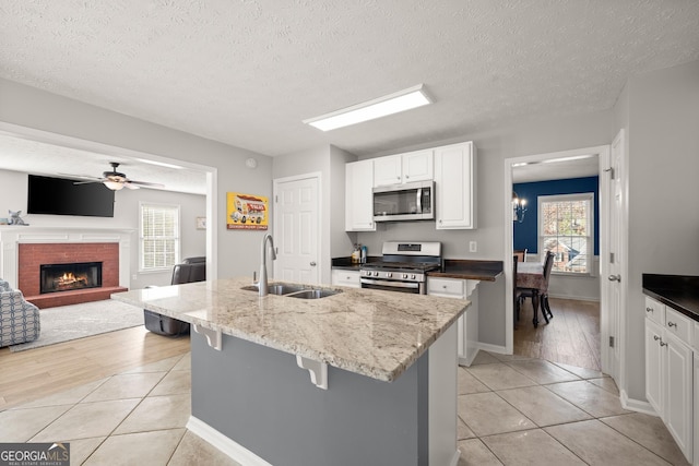 kitchen featuring a wealth of natural light, sink, stainless steel appliances, and light wood-type flooring