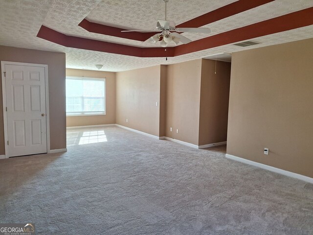 spare room with carpet flooring, ceiling fan, and a textured ceiling