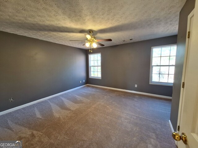 unfurnished bedroom featuring a textured ceiling, a spacious closet, a closet, and ceiling fan