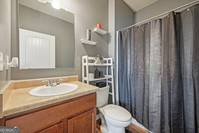 bathroom featuring a shower with shower curtain, vanity, and toilet