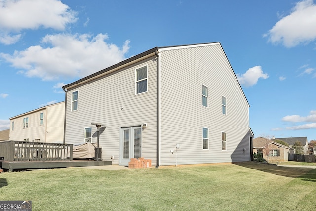 back of house with a wooden deck and a yard