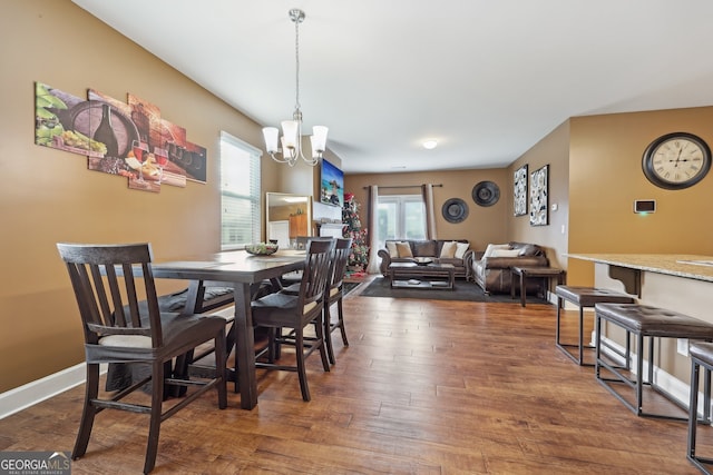 dining room with dark hardwood / wood-style flooring and a chandelier