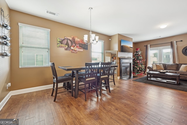 dining room with hardwood / wood-style floors and a chandelier