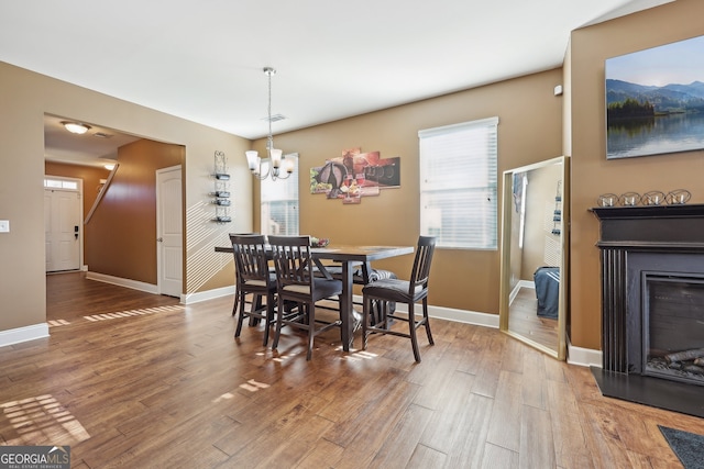 dining area with hardwood / wood-style flooring and a notable chandelier