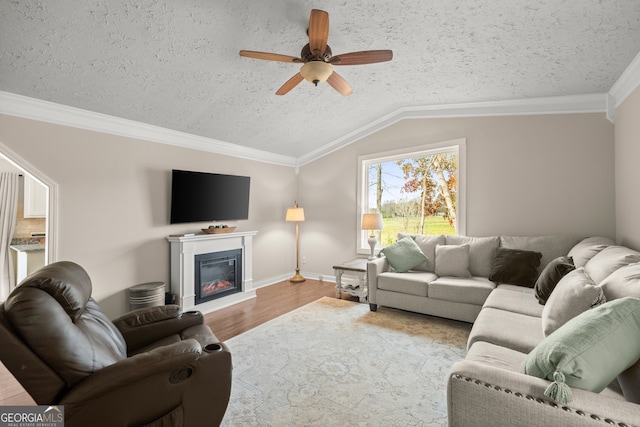 living room featuring a textured ceiling, ceiling fan, crown molding, hardwood / wood-style floors, and lofted ceiling