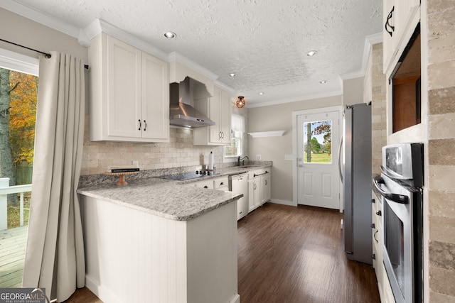 kitchen featuring white cabinetry, wall chimney exhaust hood, light stone counters, dark hardwood / wood-style floors, and appliances with stainless steel finishes