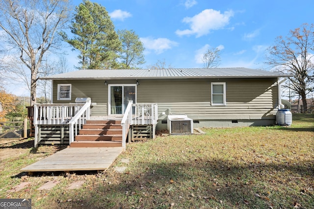 back of house with central air condition unit, a yard, and a wooden deck