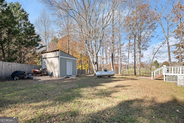 view of yard with a deck and a storage unit