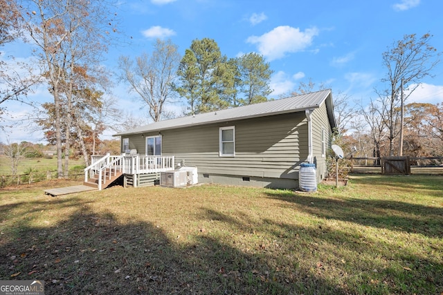 rear view of property featuring a yard and a deck