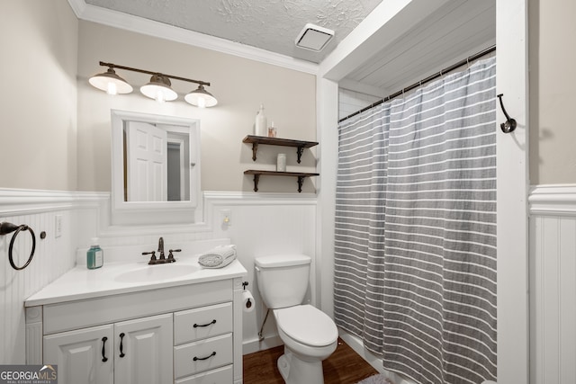 bathroom with vanity, crown molding, hardwood / wood-style flooring, toilet, and a textured ceiling