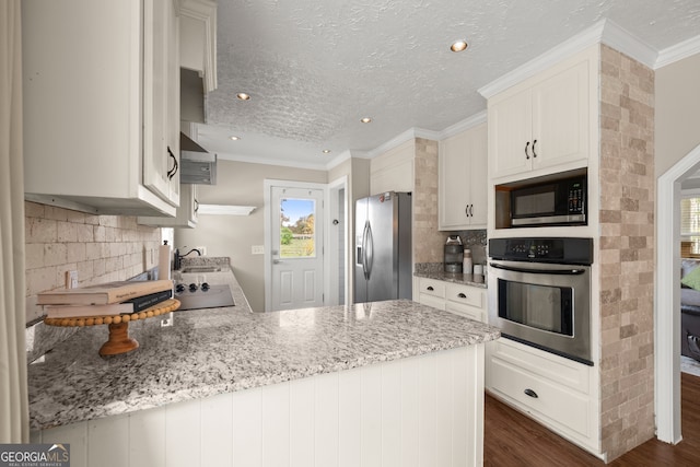 kitchen with kitchen peninsula, appliances with stainless steel finishes, dark hardwood / wood-style flooring, light stone countertops, and white cabinetry