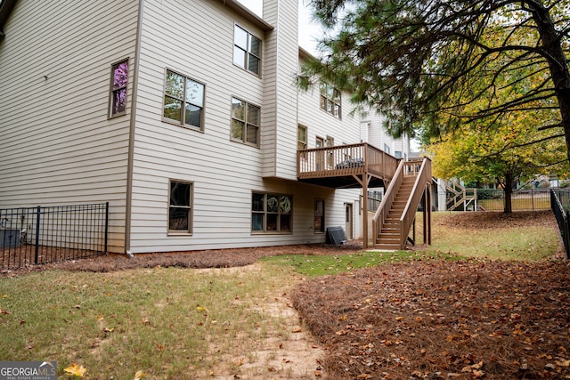 back of property with a wooden deck and a yard